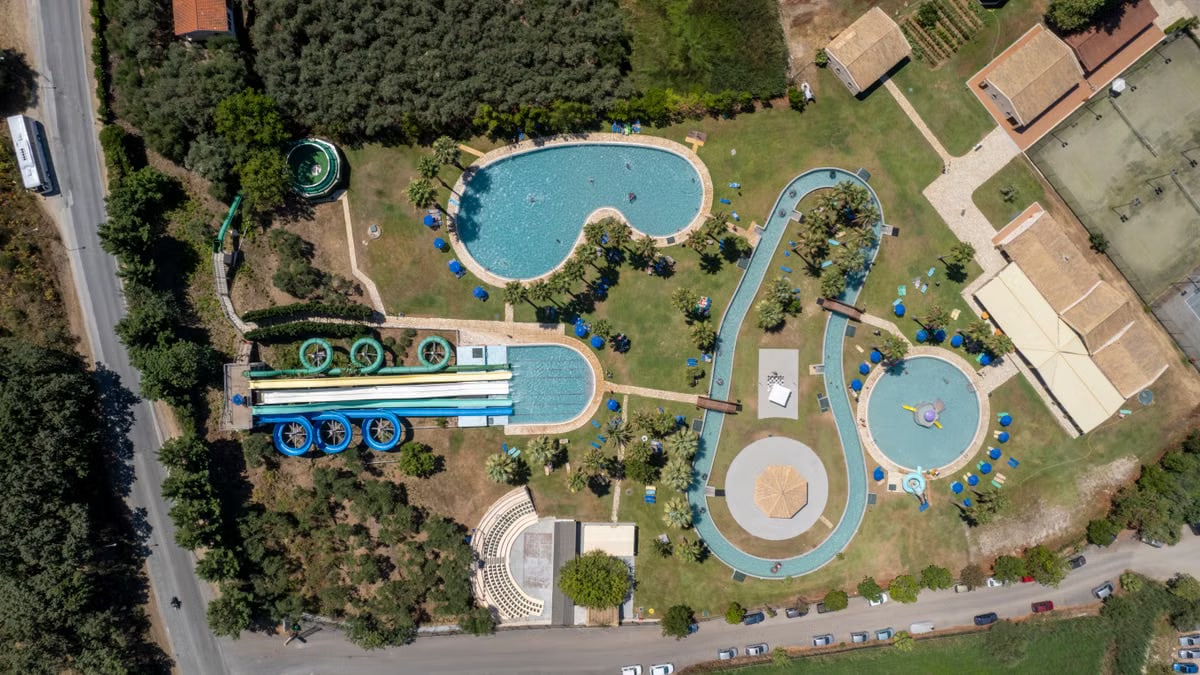 Aerial shot of a vibrant water park in Corfu, Greece, featuring pools and slides.